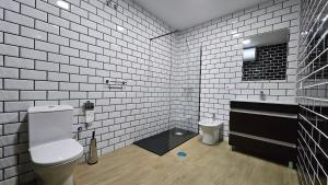baño con aseo y paredes de azulejos blancos. en Optimus Caura, en Coria del Río 42 fotos más