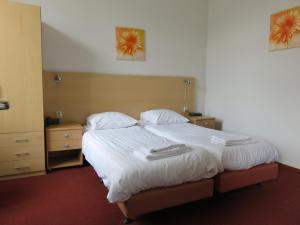 een slaapkamer met een groot bed en 2 nachtkastjes bij Hotel American in Venlo