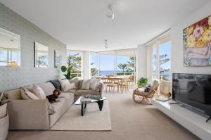 a living room with a dog laying on a couch at Best Beachfront Location In Manly w Stunning Views in Sydney