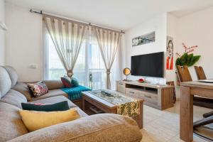 a living room with a couch and a tv at Apartamento Martin y Rose en Salou in Salou
