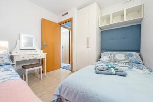 a bedroom with a bed and a desk with a computer at Apartamento Martin y Rose en Salou in Salou +18 photos