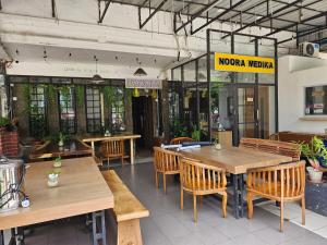 a restaurant with wooden tables and wooden chairs at N Hotel Syariah in Tanjung Pinang