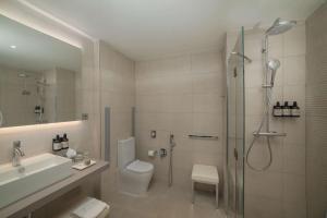 a bathroom with a shower and a toilet and a sink at NH Trieste in Trieste