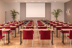 a room with tables and chairs and a whiteboard at NH Trieste in Trieste