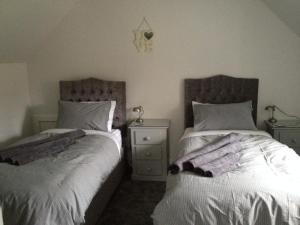 twee bedden naast elkaar in een slaapkamer bij The Old Laundry at Allt A'Mhuilinn in Spean Bridge