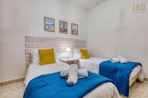 San ĠwannにあるCharming 3BR Maisonette with private Backyard & AC by 360 Estatesの青と白の部屋にベッドが2つある