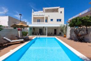 a villa with a swimming pool in front of a house at Dimora Nesea in Cozze