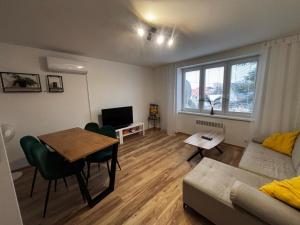 a living room with a table and a couch at Lovely Apartment Vadaš in Štúrovo