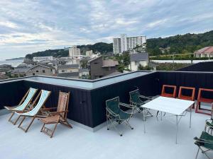 a group of chairs and a table on a roof at Wave Villa with Ocean Views in Onjuku