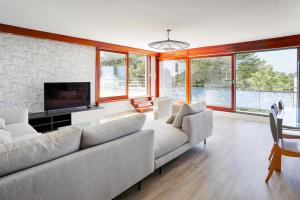 a living room with a couch and a tv at Spacious T4 with Wifi on the seafront in Saint-Philibert