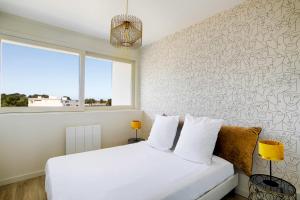 a bedroom with a white bed and a window at Spacious T4 with Wifi on the seafront in Saint-Philibert