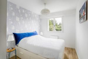a white bedroom with a bed and a window at Spacious T4 with Wifi on the seafront in Saint-Philibert +10 photos