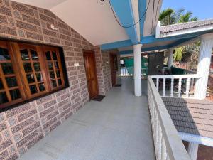 a house with a brick wall and a walkway at HostelVK Gokarna in Gokarna