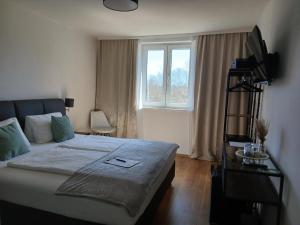 a bedroom with a large bed and a window at Hotel Fuchs & Hase SELF CHECK IN in Rosegg