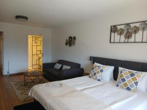 a bedroom with a bed and a couch at Hotel Fuchs & Hase SELF CHECK IN in Rosegg