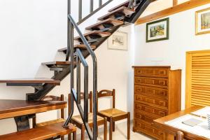 a spiral staircase in a room with a desk and a table at GuestHost Dreamy Stintino Seafront, AC and Parking in Stintino