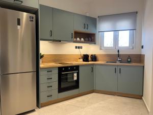 a kitchen with white cabinets and a stainless steel refrigerator at POST VIEW Center Luxury Apartments 5 in Ioannina