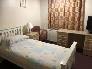 a bedroom with a bed and a desk and a desk at SJGUESTHOUSE LONDON Single Room A in London