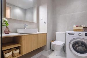 a bathroom with a sink and a washing machine at Olive Garden House in Gastourion