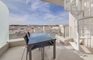 a table and chairs on a balcony with a view at Luxury Penthouse - Rooftop Pool - 100m to the Sea in Torrevieja