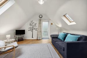 a living room with a couch and a tv at Beautiful Country Apartment, rated Exceptional in Coventry