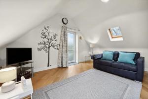 a living room with a couch and a tv at Beautiful Country Apartment, rated Exceptional in Coventry +20 photos