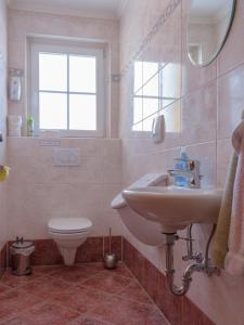 ein Bad mit einem Waschbecken, einem WC und einem Fenster in der Unterkunft Haus Maier in Flachau