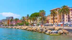 a river with rocks in front of buildings and palm trees at 5 mins to the beach, cozy home in Rapallo