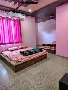 RīngasHotel Palak palace的配有粉红色窗帘的客房内的两张床
