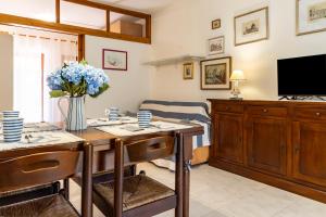 a dining room with a table and a tv at GuestHost Dreamy Stintino Seafront, AC and Parking in Stintino