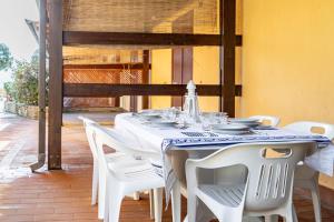 a white table with white chairs on a patio at GuestHost Dreamy Stintino Seafront, AC and Parking in Stintino
