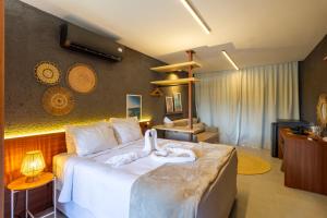 une chambre avec un grand lit avec des serviettes dessus dans l'établissement CONDOMINIO GAMBOA - 190 METROS DA PRAIA DO PATACHO, à Porto de Pedras