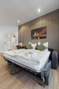 ケルンにあるModern und kinderfreundlich, 3km zu Messe, Airport Köln-Bonnの壁付きの客室の大きな白いベッド1台