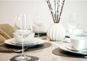 a table with plates and glasses and a vase at Central Manchester Skyline in Manchester