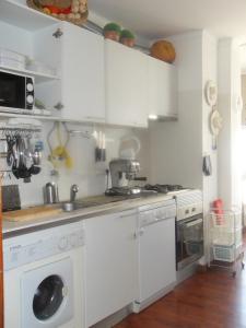cocina con armarios blancos y lavavajillas en Beach and City Apartment, en Portimão