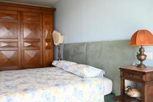 a bedroom with a bed and a wooden cabinet at CN003 - Cesenatico, bilocale fronte mare con terrazzo panoramico in Cesenatico +23 photos
