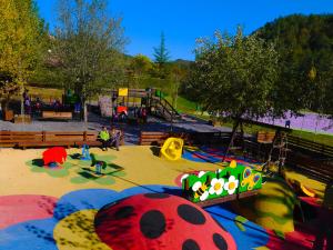a park with a playground with a play area and a slide at Càmping Riera Merlès in Borredá