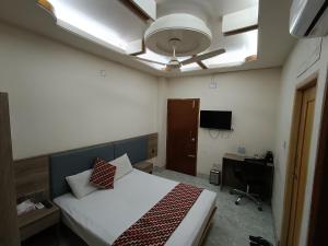 a bedroom with a bed and a ceiling fan at The Asteria Hotel Bogura in Bogra
