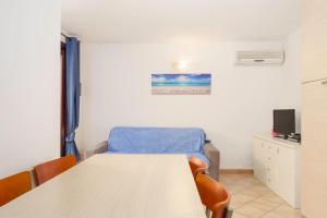 a room with a table and a chair and a tv at Residence Orizzonti app n 3 in Golfo Aranci