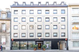 a large white building with potted plants in front of it at ibis Brussels Centre Chatelain in Brussels