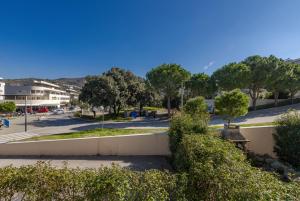 River Apartment في دوبروفنيك: اطلاله على شارع فيه اشجار وموقف سيارات