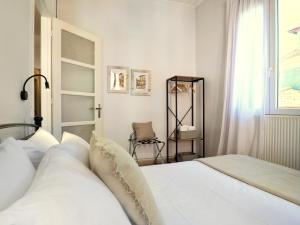 a bedroom with a white bed and a window at La Casa Buranella in Lefkada +17 photos