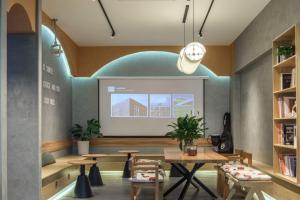 a room with tables and chairs and a projection screen at Denpa Inn-Lao Ximen Metro Station Branch in Shanghai