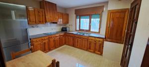 a kitchen with wooden cabinets and a table in it at Casa María in Vinarós