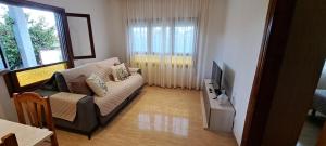 a living room with a couch and a tv at Casa María in Vinarós