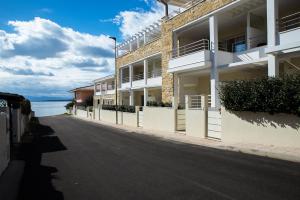 a row of apartment buildings on a street next to the water at Cormorani appartamento N 5 in Golfo Aranci