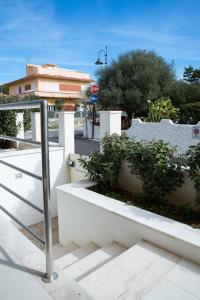 a group of plants in white planters on a sidewalk at Cormorani appartamento N 5 in Golfo Aranci