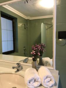 a bathroom with a sink and a mirror and towels at Utopia Konak Otel in Bozuyuk