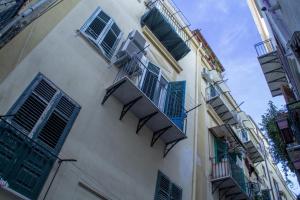 a tall white building with blue shuttered windows at Tourist House Palermo in Palermo