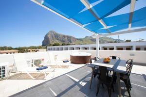 a patio with a table and chairs on a roof at ITACA e MEDEA - Appartamenti con idromassaggio in terrazza in San Vito lo Capo